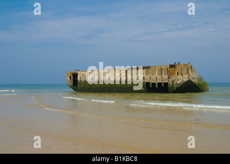 Part of the Muberry Harbour washed ashore onto Gold Beach of the D Day landings Arromanched Les Bains Normandy Stock Photo