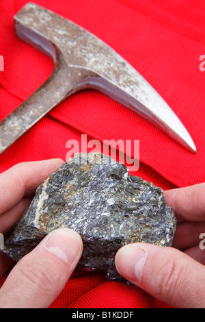 Mining  concept of ore sample and geologists rock hammer Stock Photo