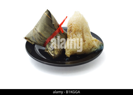 Wrapped and unwrapped Chinese rice dumplings on plate Stock Photo