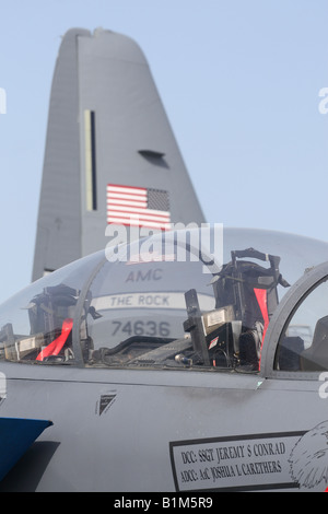 USAF military air power Boeing F-15E Strike Eagle cockpit canopy with Lockheed Martin C-130 Hercules tail behind Stock Photo