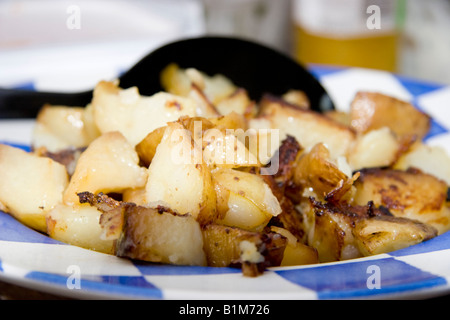 Diced freshly roasted potatoes on a blue and white striped plate