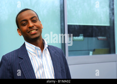Portrait of a young attractive businessman next to a corporate building Stock Photo