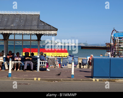 holidaymakers relaxing in the shade of a beach shelter on the promenade at Weymouth,Dorset,UK. Stock Photo