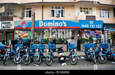 INDIA MUMBAI MAHARASHTRA Domino s Pizza franchise in Mumbai India with motorcycles lined up in front to deliver pizzas Stock Photo