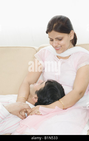 Mid adult man lying on the lap of a mid adult woman and smiling Stock Photo