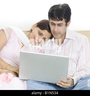 Mid adult couple using a laptop and smiling Stock Photo