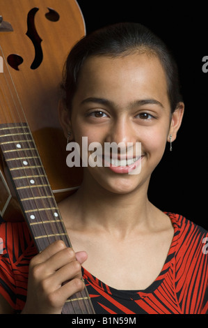 Girl standing and holding electric guitar Stock Photo - Alamy