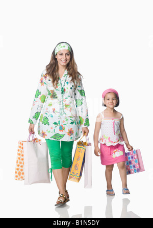 Portrait of a young woman with her daughter holding shopping bags and smiling Stock Photo