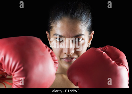 Portrait of a young woman wearing boxing gloves Stock Photo