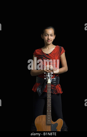 Girl standing and holding electric guitar Stock Photo - Alamy