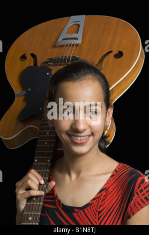 Girl standing and holding electric guitar Stock Photo - Alamy
