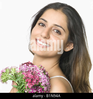 Portrait of a young woman holding a bunch of flowers and smiling Stock Photo