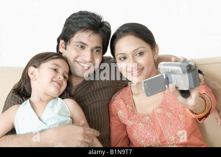 Close-up of a couple with their daughter filming themselves Stock Photo