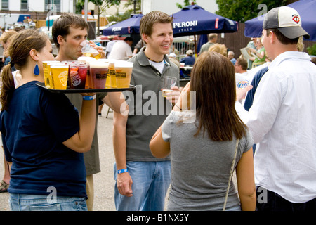 Waitress delivering beer and other drinks to people having fun. Grand Old Day Street Fair St Paul Minnesota USA Stock Photo