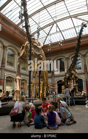 German schoolchildren listen to lecture on sightseeing tour at the Dinosaur hall in Museum fur Naturkunde natural history museum in Berlin, Germany Stock Photo