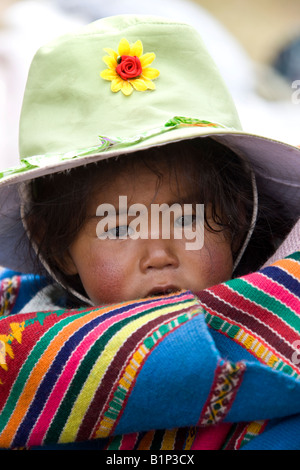 Peruvian child being carried on her mothers back in Puno in Southern Peru in South America Stock Photo