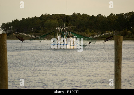 shrimp trawler lets down its nets as it head to open sea down Carrabelle River Carrabelle Florida Stock Photo