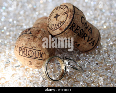 An engagement and a wedding ring next to two champagne corks used on the wedding day Stock Photo