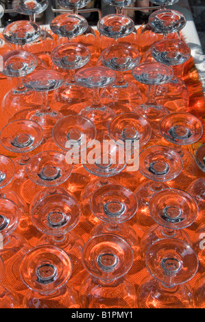 rows of upturned water or wine glasses on table cloth Stock Photo