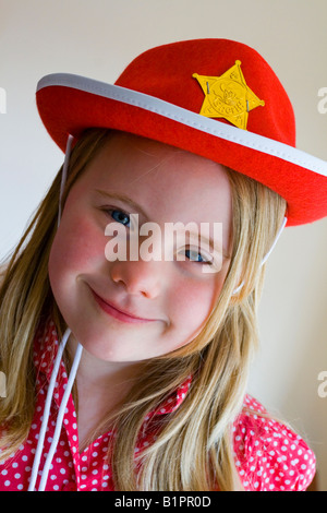 Six year old girl wearing red cowboy hat with gold star smiling at camera Stock Photo