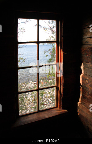 VIEW OF A ROCKY LAKE MICHIGAN SHORE FROM A WINDOW IN A RUSTIC LOG CABIN IN DOOR COUNTY WISCONSIN USA Stock Photo