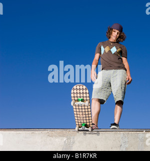 Skateboarder at top of half pipe Stock Photo