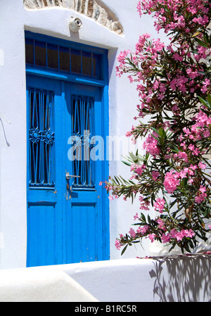 old greek island wood door with cyclades architecture flowering tree ancient construction Stock Photo