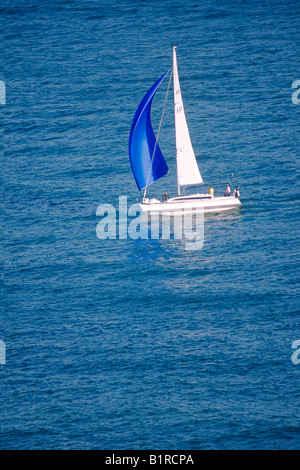 Sailing Boat with Spinnaker on Blue Sea Stock Photo