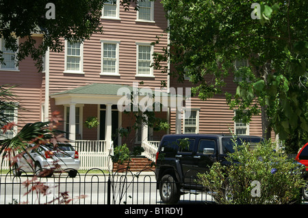 Pink Clapboard House with White Windows and Porch, white picket fence Stock Photo