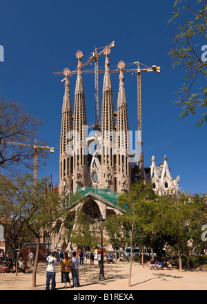 Tourists in front of La Sagrada Familia Church designed by the architect Antoni Gaudí, panoramic view made out of 3 separate pi Stock Photo