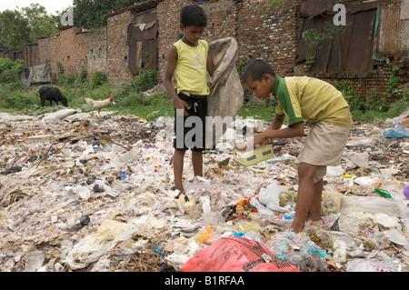 Two boys rummaging through a garbage dump site to earn a few rupees from recyclable waste in the slums of Howrah, Hooghly, West Stock Photo