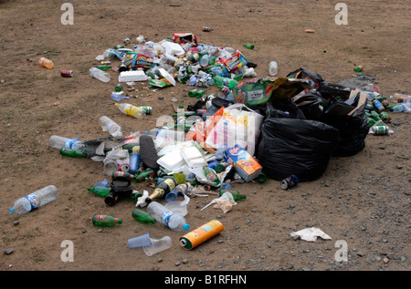 Bags of rubbish, cans and bottles, dumped in a field. Stock Photo