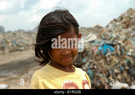 Sad girl rummaging through rubbish at the Stung Meanchey Municipal Garbage Dump in the south of Cambodia's capital Phnom Penh w Stock Photo
