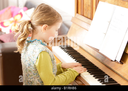 Girl, 8 years old, playing piano Stock Photo