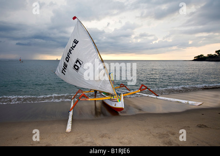 Fisherman coming ashore on his catamaran at dusk, beach of Senggigi, Lombok Island, Lesser Sunda Islands, Indonesia, Asia Stock Photo