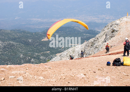 Paragliding off Babadag mountain in Fethiye Turkey. Extreme sports in Turkey. Aerial views overlooking Olu Deniz beach holiday resort. Mountain top Stock Photo