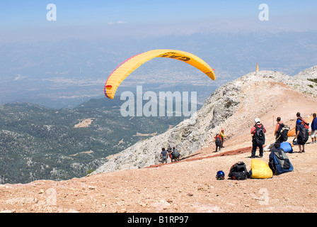 Paragliding off Babadag mountain in Fethiye Turkey. Extreme sports in Turkey. Aerial views overlooking Olu Deniz beach holiday resort. Mountain top Stock Photo