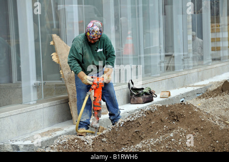 Construction worker with jackhammer working on a New York City sidewalk, Manhattan, USA Stock Photo