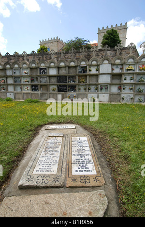 Grave in a family burial plot beneath engraved stone slabs in the cemetery of the Iglesia de Santiago de Cereixo Church in Cama Stock Photo