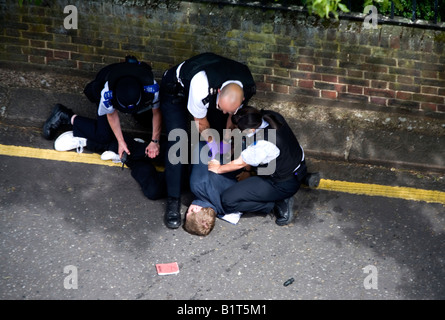 Police handcuffing a suspect criminal in the streets of London England Britain Uk