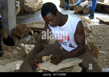 A wood carver draws a design on a piece of wood, Aburi, Eastern Region, Ghana Stock Photo