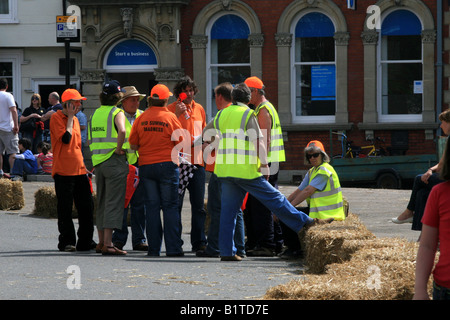 Race marshalls and officials gather wearing orange and day glo yellow Stock Photo