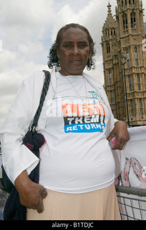 Chagos islander wears t-shirt 'LET THEM RETURN' in front of Houses of Parliament as Lords consider government appeal. Stock Photo