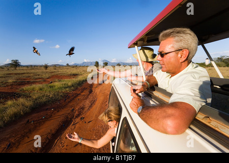 Tourists in a safari bus feeding birds Taita Hills Game Reserve Coast Kenya Stock Photo