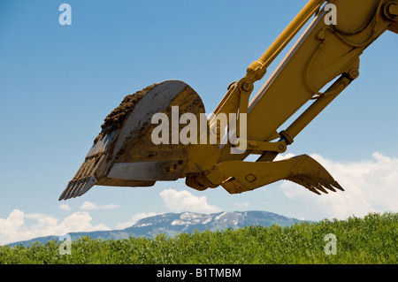 Scoop of a Caterpillar 315CL track excavator, Mt Werner and ski slopes in background, Dig This, Steamboat Springs, Colorado. Stock Photo