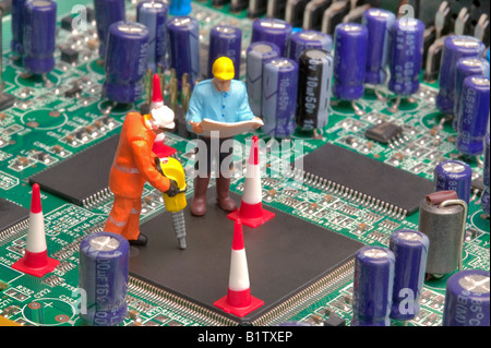 Mini workmen repairing a broken circuitboard part of a series of images along this theme Stock Photo