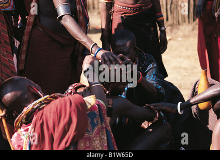 Maasai Moran having his head shaved by mother at Eunoto ceremony Southern Kenya East Africa Stock Photo