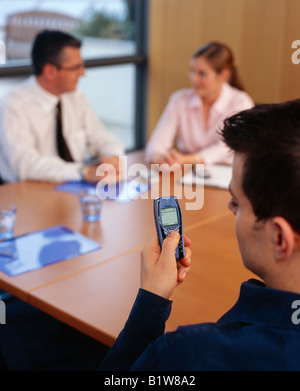 man texting on mobile phone at business meeting Stock Photo