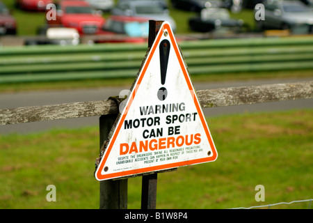 Warning sign motor sport can be dangerous track side Stock Photo