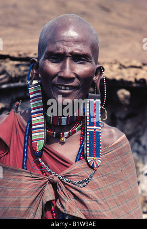 Maasai woman in traditional dress wearing ear ornaments of beaded leather panels Masai Mara National Reserve Kenya East Africa Stock Photo